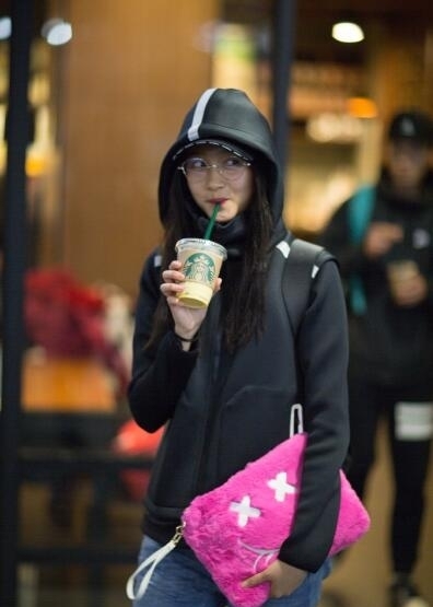 关晓彤学生装扮现身机场 边走边喝咖啡窃喜比耶