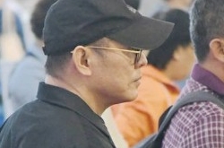 李连杰低调现身机场无人识 没保镖护行如普通市